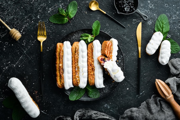 Eclair à la crème Dessert crémeux sur une assiette en pierre noire Vue de dessus Style rustique