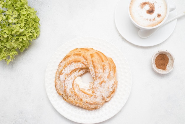 Eclair de gâteau à la crème avec café et hortensias sur fond gris