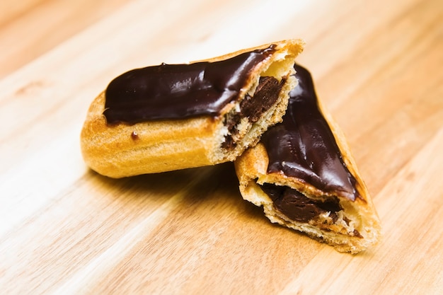 Photo eclair gâteau crémeux croustillant au chocolat noir est plaqué sur une surface en bois