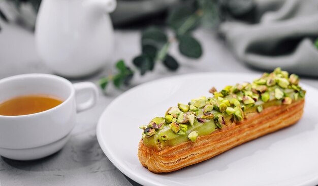 Photo Éclair sucré avec des pistaches sèches sur assiette