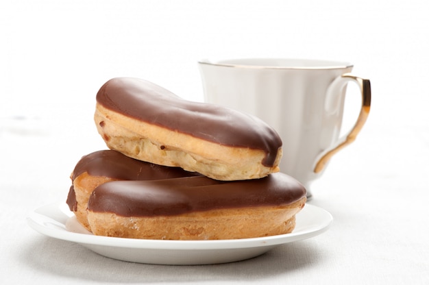 Photo Éclairs au chocolat sur une plaque sur blanc isolé