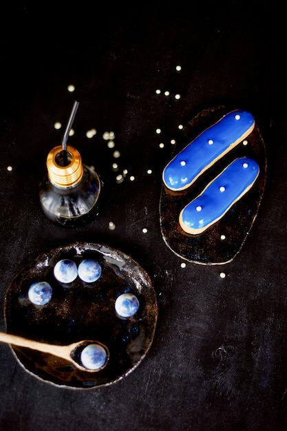 Eclairs bleus et bonbons aux couleurs bleuesSur fond sombre Arts de la pâtisserie