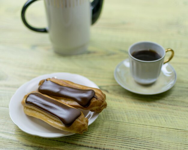 Eclairs et café sur un fond en bois