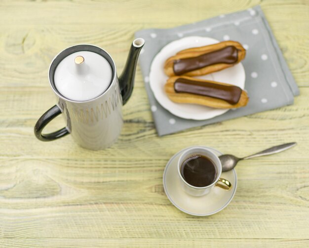 Eclairs et café sur un fond en bois