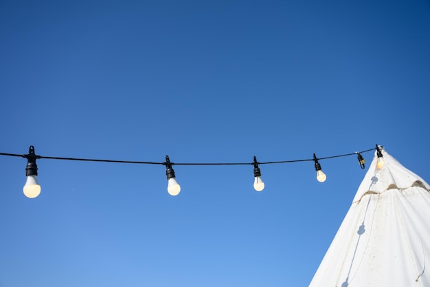 L'éclat de l'ampoule accroché au pavillon avec un ciel bleu