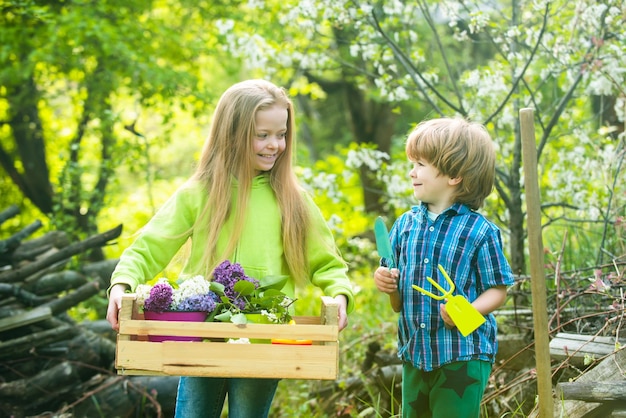 Eco living fils et fille plantant sur le sol doux concept de printemps de l'enfance nature et soins