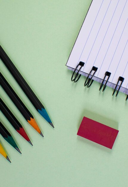 L'école fournit un porte-papier pour ordinateur portable sur fond vert clair à l'école. Vue de dessus au-dessus de la tête