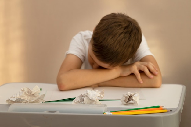 Un écolier de 10 ans faisait ses devoirs très fatigué et dormait à son bureau