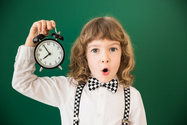 Photo Écolier en classe. enfant heureux contre le tableau vert. notion d'éducation