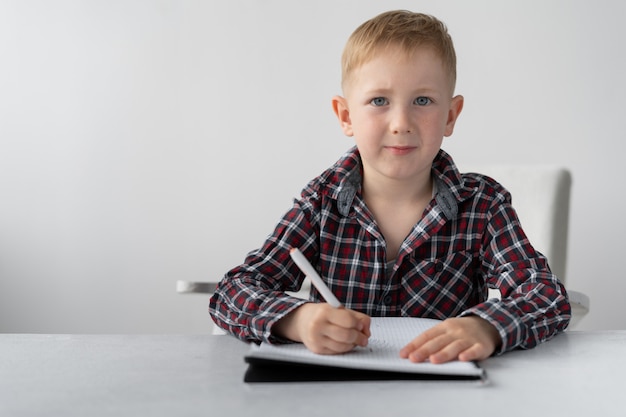 Un écolier fait ses devoirs de quarantaine à la maison.