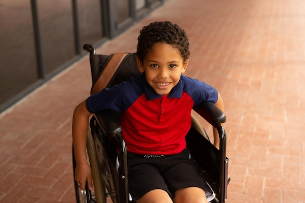 Photo un écolier handicapé heureux regardant la caméra dans le couloir.