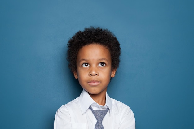 Un écolière afro-américain de 6 ans sur un portrait bleu