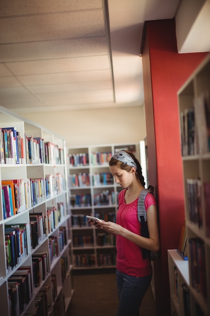 Écolière Attentive à L'aide De Tablette Numérique Dans La Bibliothèque