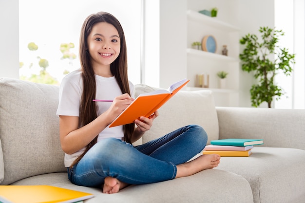 écolière élève responsable faire ses devoirs tenir stylo écrire bloc-notes