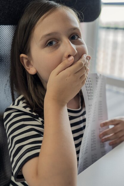 Une écolière fait ses devoirs à la maison. Le concept de retour à l'école.