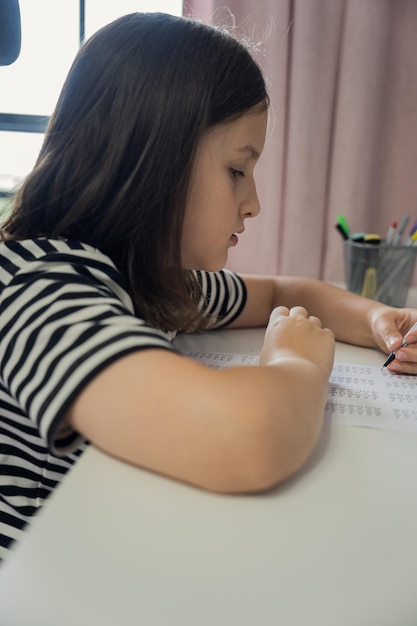 Une écolière fait ses devoirs à la maison. Le concept de retour à l'école.