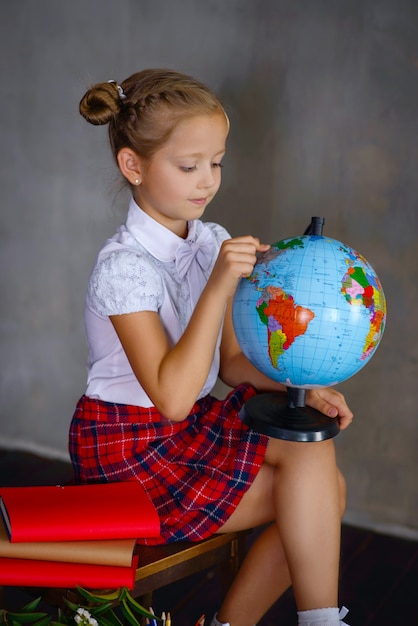 Photo Écolière avec globe terrestre. concept d'école