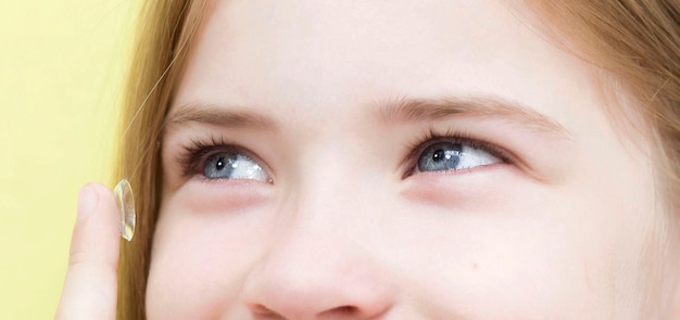 Une écolière insère des lentilles de contact dans ses yeux.