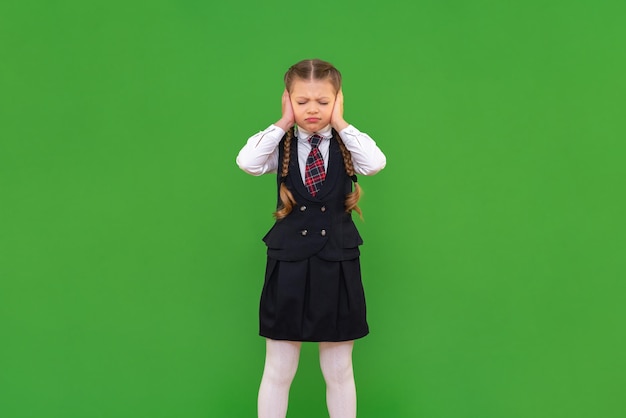 Une écolière de mauvaise humeur a couvert ses oreilles avec ses paumes l'élève ne veut rien écouter de mauvaise école l'enfant ne veut pas étudier