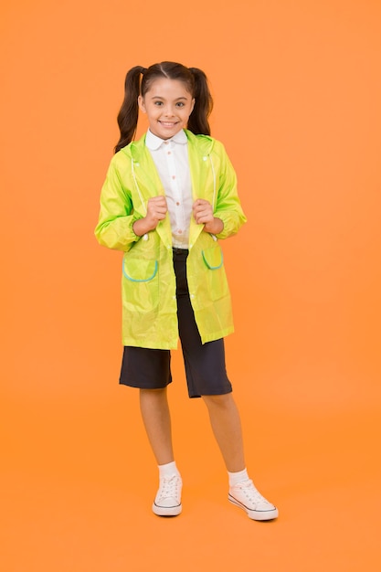 Une écolière mignonne se sent protégée. Bonne écolière porter un imperméable. Investissez dans des vêtements de pluie pour enfants durables pour garder les enfants à l'air frais. Conception étanche. Les petites écolières portent des vêtements résistants à l'eau.