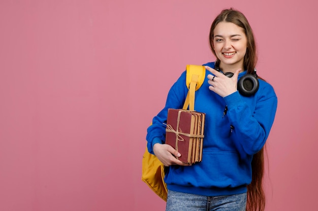 Écolière à la mode avec de longs cheveux debout avec un clin d'œil