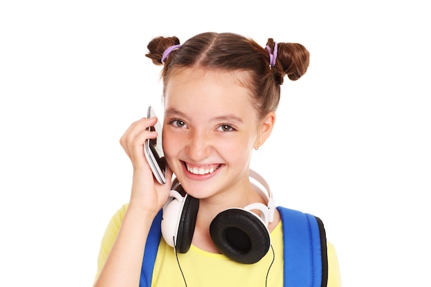 Une écolière parlant au téléphone sur fond blanc