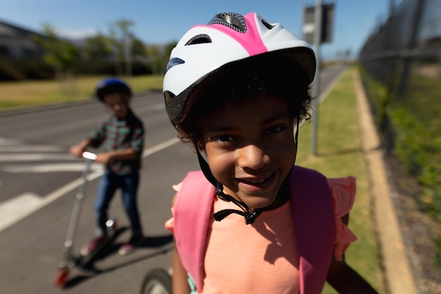 Écolière portant un casque de vélo et souriant à la caméra