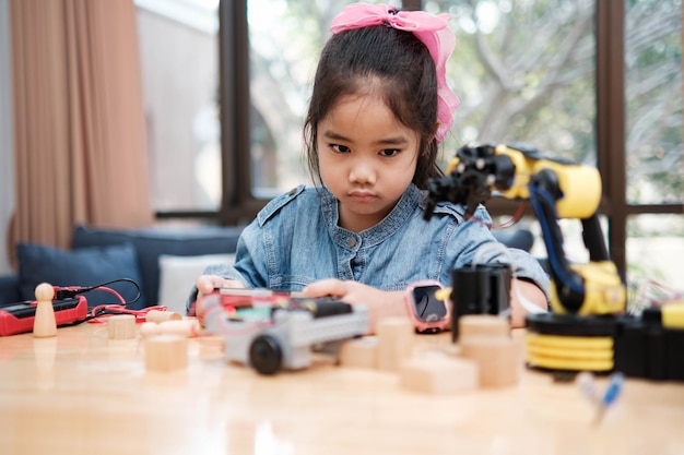 Photo une écolière utilise une application pour contrôler une voiture en classe de stem