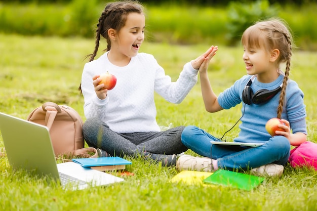Les écolières mignonnes mangent à l'extérieur. Déjeuners sains pour les écoliers. Boîte à lunch avec des fruits. Déjeuner scolaire.
