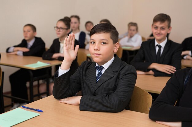 Des écoliers heureux s'assoient à un bureau dans la salle de classe