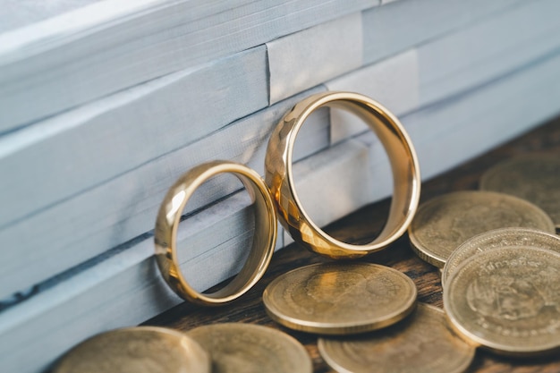 Économisez de l'argent et planifiez le concept de mariage Objectif financier durable pour la vie de famille ou la vie conjugale Des anneaux avec une pile de pièces permettant d'économiser de l'argent pour se marier représentent des économies ou une croissance pour une nouvelle famille