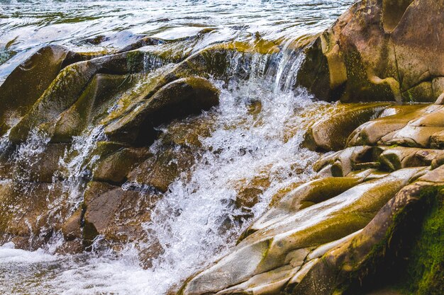 écoulement rapide de l'eau parmi les pierres lisses dans la rivière de montagne