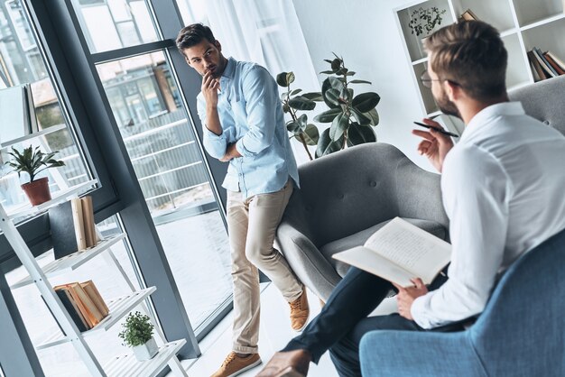 A l'écoute du médecin. Jeune homme frustré regardant un psychologue