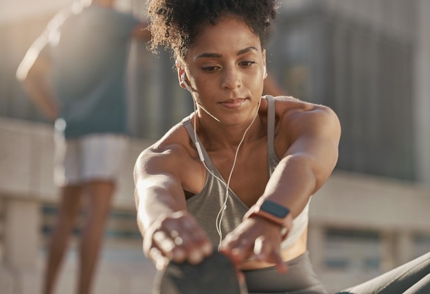 Photo Écouteurs de musique et femme noire s'étirant pour la remise en forme, échauffement, exercice cardio et entraînement pour la course de marathon engagement pour la santé de l'entraînement et coureur écoutant la radio ou le podcast audio en streaming