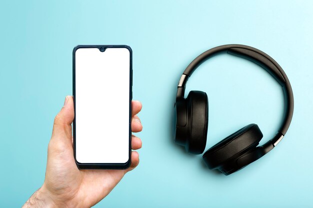 Les écouteurs avec smartphone simulent des écouteurs audio sonores sur un fond néon coloré avec un blanc ...