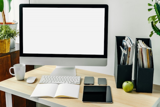 Photo Écran d'ordinateur avec maquette d'écran blanc sur une table de bureau avec des fournitures