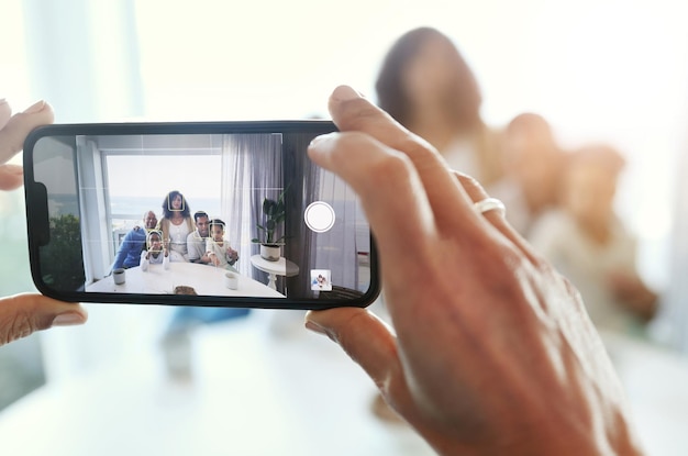 Écran de photographie de smartphone et main avec la famille à la maison prenant des photos et de la mémoire avec amour et soin Gros plan technologique et personnes avec objectif de mise au point et application de photographe et téléphone