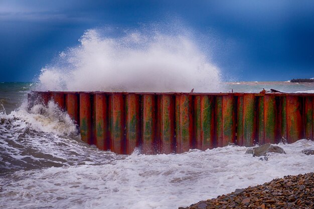 Photo Écrasement de pierre de vague de mer au brise-lames