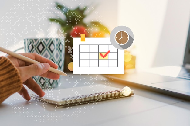 Écriture à la main sur bloc-notes avec icône de calendrier sur la table