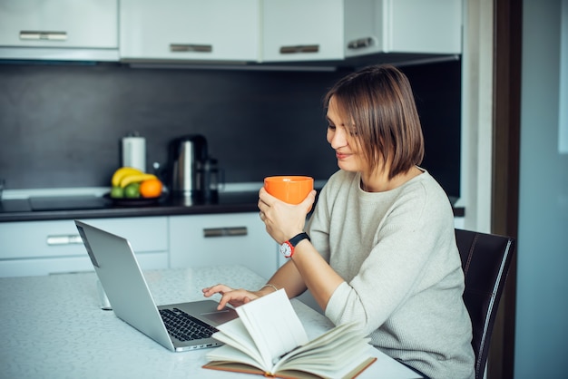 L'écrivaine travaille à la maison et boit du café. Indépendant, travail à distance, créativité.