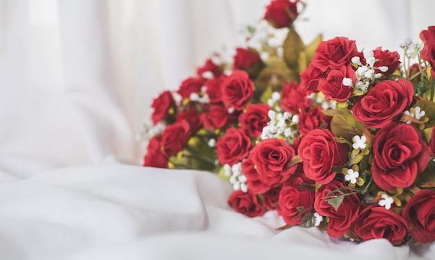 ed roses sur un fond de mastic blanc soie. Fleurs rouges parfumées, concept cadeau pour la Saint-Valentin