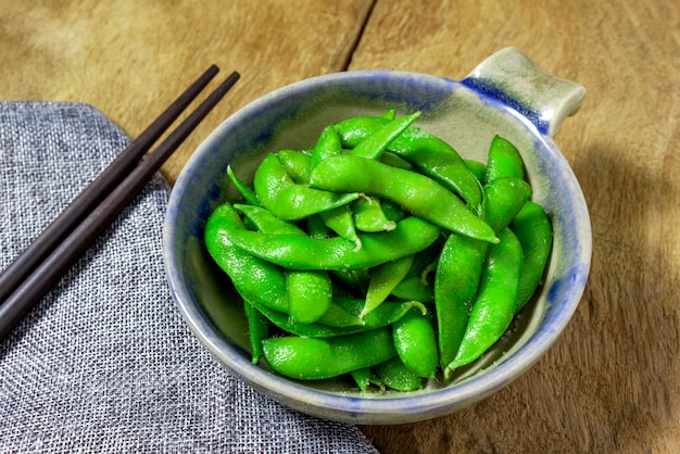 Edamame grignote, soja vert bouilli, cuisine japonaise, vue de dessus sur la table en bois