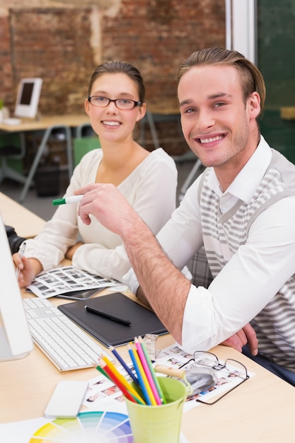 Photo Éditeurs de photo souriant au travail dans le bureau