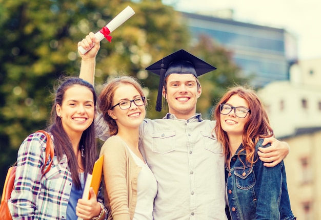 éducation, campus et concept adolescent - groupe d'étudiants ou d'adolescents avec fichiers, dossiers, lunettes et diplôme