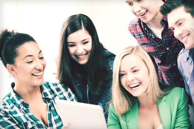 éducation et internet - étudiants souriants regardant tablet pc en cours à l'école