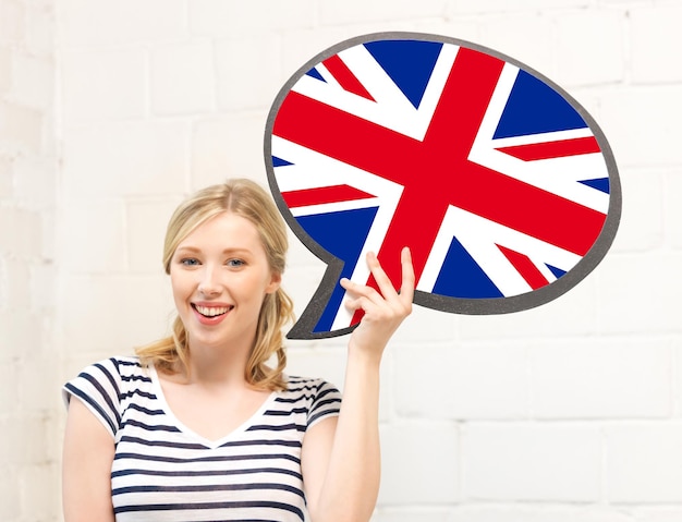 Photo Éducation, langue étrangère, anglais, concept de personnes et de communication - femme souriante tenant une bulle de texte du drapeau britannique