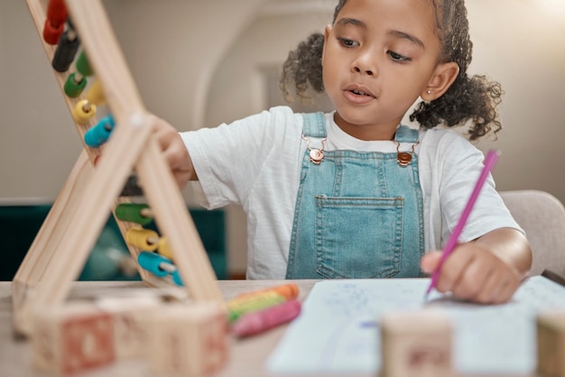 Photo Éducation à la maison et fille avec un boulier de mathématiques prête pour le développement de la maternelle dans une maison connaissance de l'étude scolaire et test d'écriture de nombres avec un enfant faisant des mathématiques avec concentration