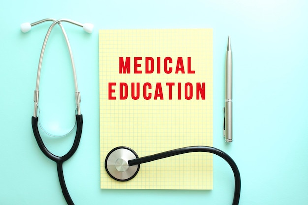 L'éducation médicale en texte rouge est écrite dans un tampon jaune qui se trouve à côté du stéthoscope
