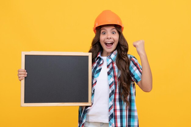 L'éducation de la petite enfance. copiez l'espace pour l'annonce. bonne journée des employés. heureux ouvrier adolescente tenir le tableau noir. fête du travail de la publicité pour les enfants. retour à l'école. enfant présentant des informations sur la nouveauté.