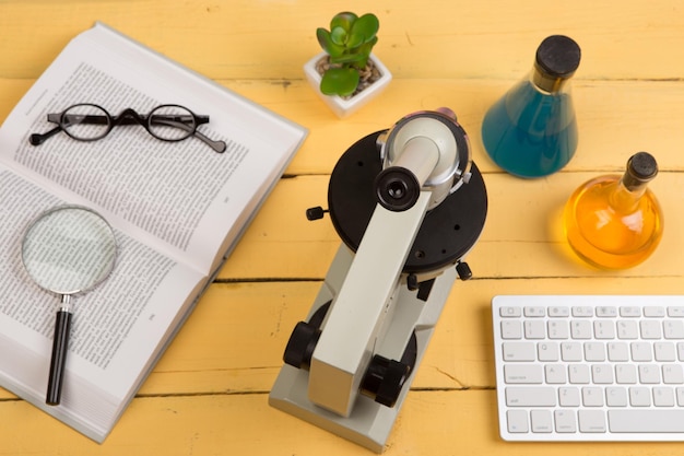 L'éducation et la science concept microscope livre loupe lunettes et liquide chimique